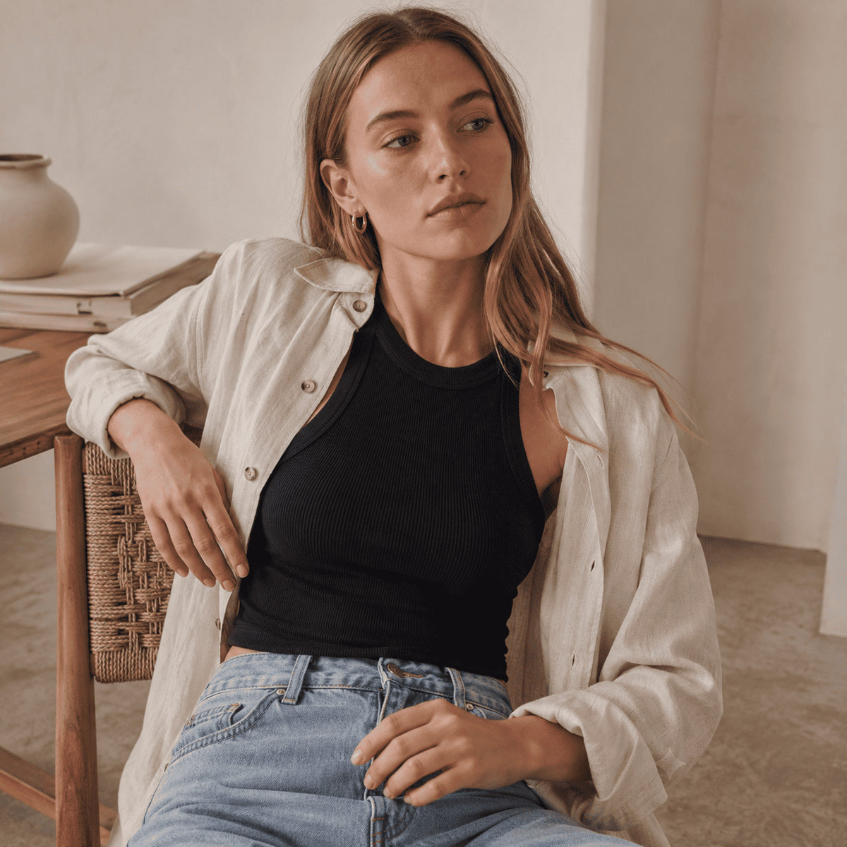 Top à brassière intégrée noir porté avec une chemise blanche et un jean